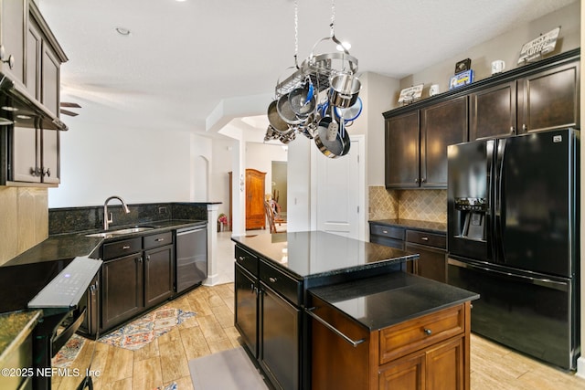 kitchen featuring a center island, black fridge with ice dispenser, wood tiled floor, a sink, and dishwasher