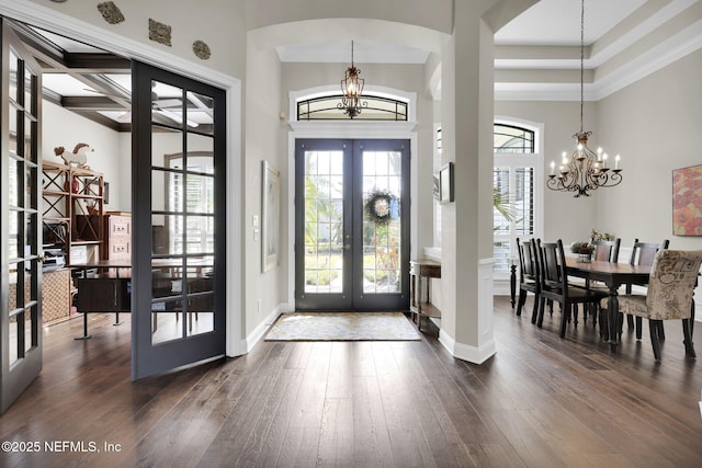 foyer featuring dark hardwood / wood-style floors, french doors, and a chandelier