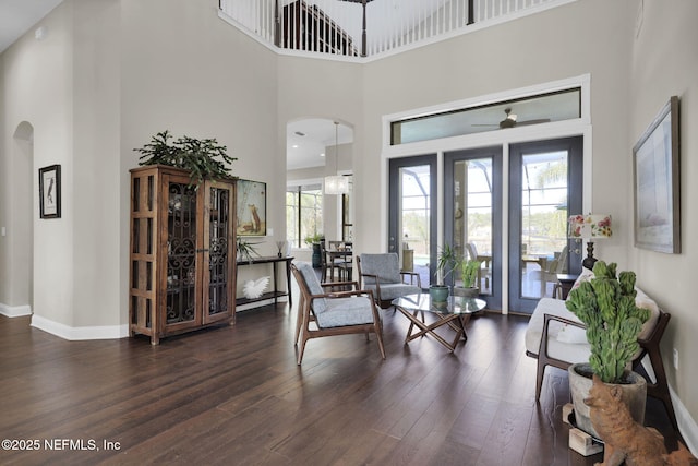 interior space with dark hardwood / wood-style floors, ceiling fan, and a towering ceiling