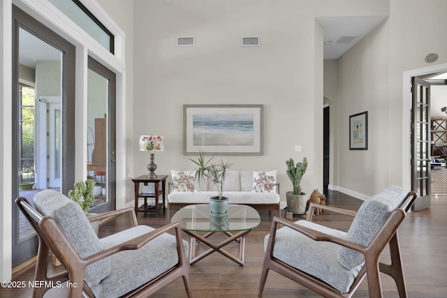 living room featuring hardwood / wood-style flooring and a towering ceiling