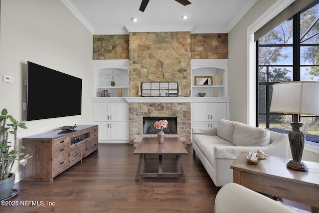 living room with crown molding, a fireplace, dark hardwood / wood-style flooring, and built in features