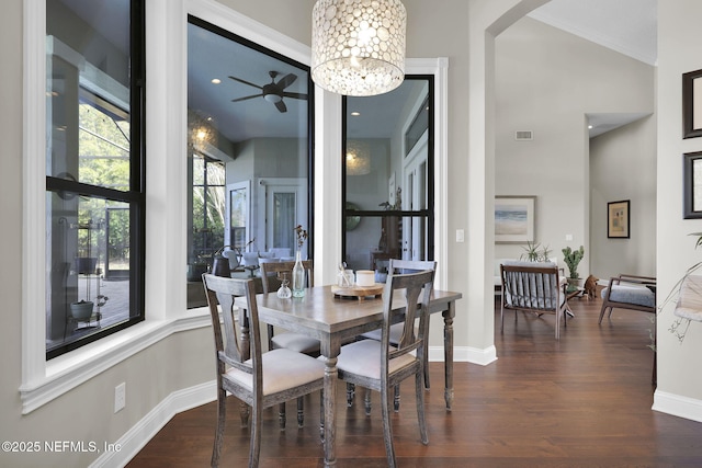 dining room with an inviting chandelier, dark wood-type flooring, and a high ceiling