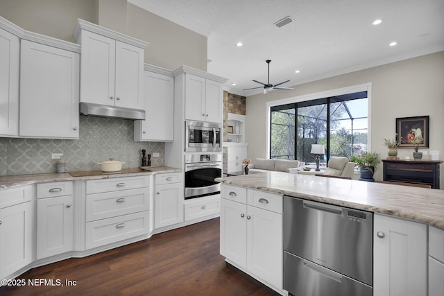 kitchen featuring stainless steel appliances, exhaust hood, white cabinets, and light stone counters