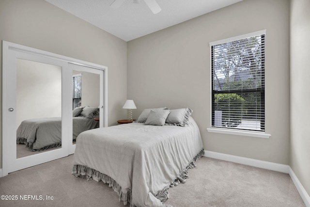 bedroom featuring ceiling fan, multiple windows, and light carpet