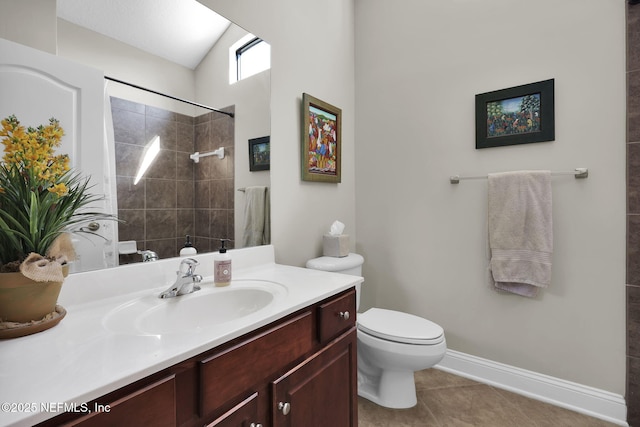 bathroom with tile patterned flooring, vanity, a tile shower, vaulted ceiling, and toilet