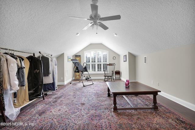 playroom with ceiling fan, lofted ceiling, and a textured ceiling