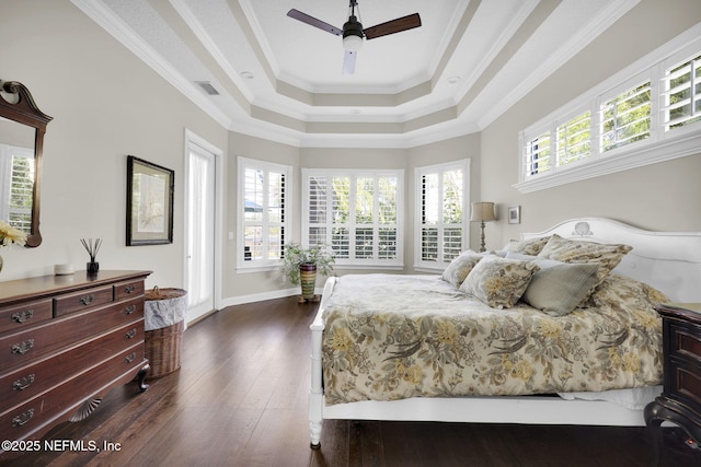 bedroom with crown molding, ceiling fan, dark hardwood / wood-style flooring, and a tray ceiling