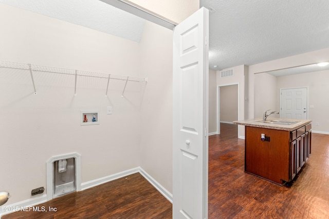 washroom with hookup for a washing machine, sink, a textured ceiling, and dark hardwood / wood-style flooring