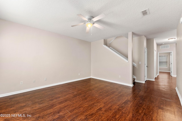 unfurnished living room with dark wood-type flooring, ceiling fan, and a textured ceiling