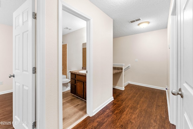 hall with dark hardwood / wood-style floors and a textured ceiling