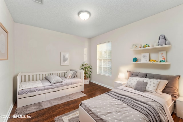 bedroom featuring a textured ceiling and dark hardwood / wood-style flooring