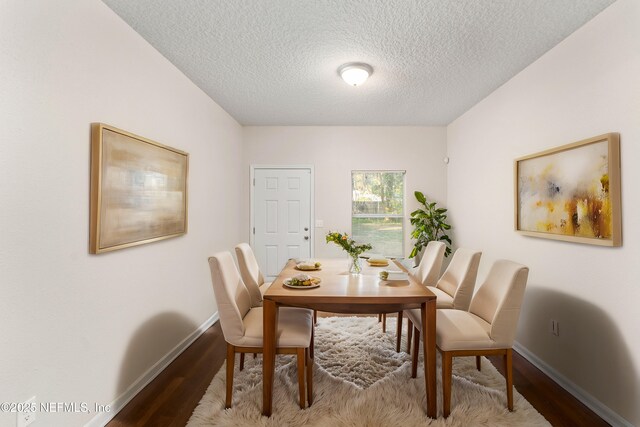 dining area with a textured ceiling and light wood-type flooring