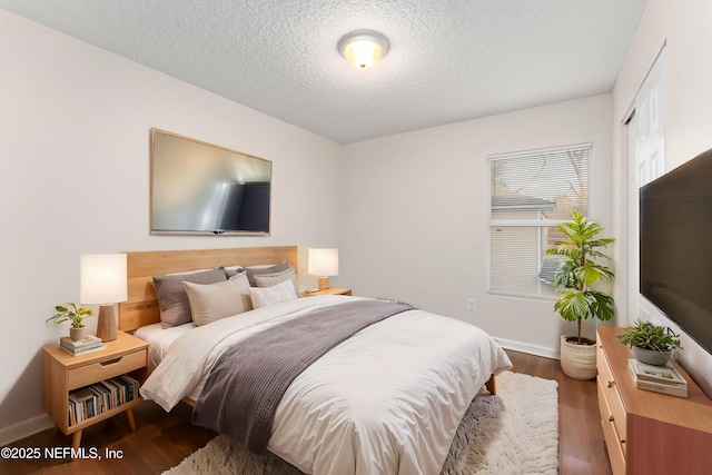 bedroom with hardwood / wood-style flooring and a textured ceiling