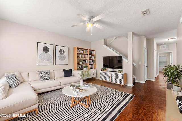 living room with ceiling fan, dark hardwood / wood-style floors, and a textured ceiling