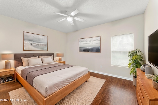 bedroom with ceiling fan, dark hardwood / wood-style flooring, and a textured ceiling