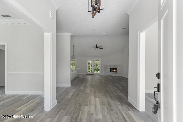 corridor with crown molding, vaulted ceiling, and light wood-type flooring