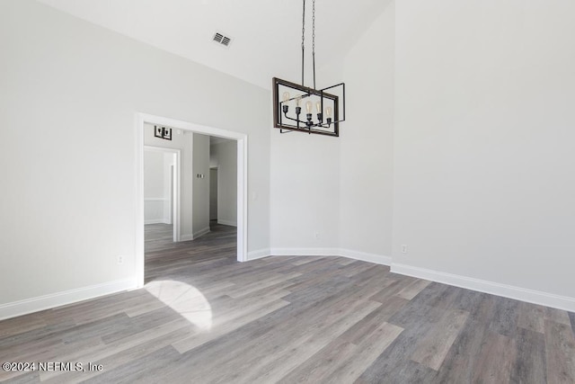 unfurnished dining area with hardwood / wood-style flooring and a chandelier