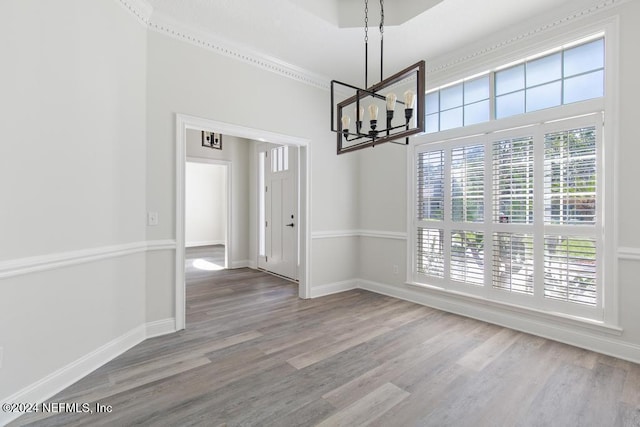 unfurnished dining area featuring wood-type flooring and a chandelier