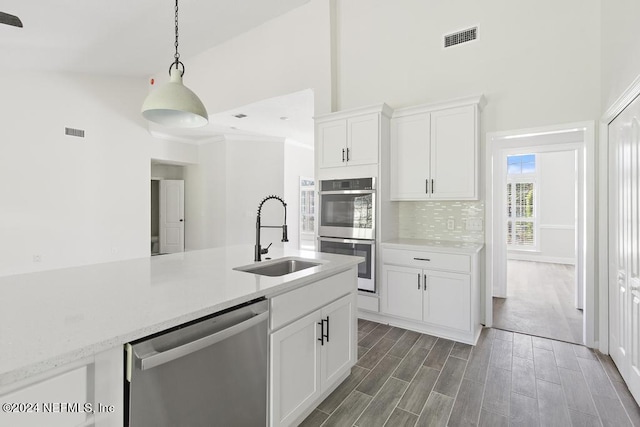 kitchen featuring stainless steel appliances, sink, white cabinets, and decorative backsplash