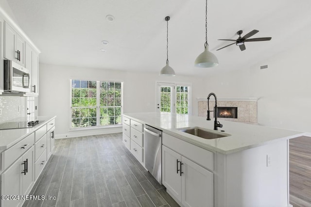 kitchen featuring sink, white cabinetry, stainless steel appliances, a center island with sink, and dark hardwood / wood-style flooring