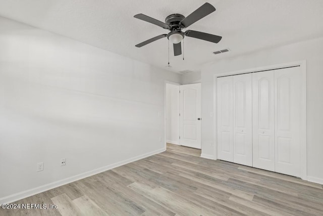 unfurnished bedroom featuring light hardwood / wood-style flooring, a closet, and ceiling fan