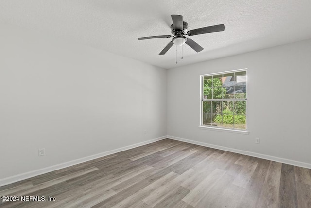 spare room featuring ceiling fan, light hardwood / wood-style flooring, and a textured ceiling