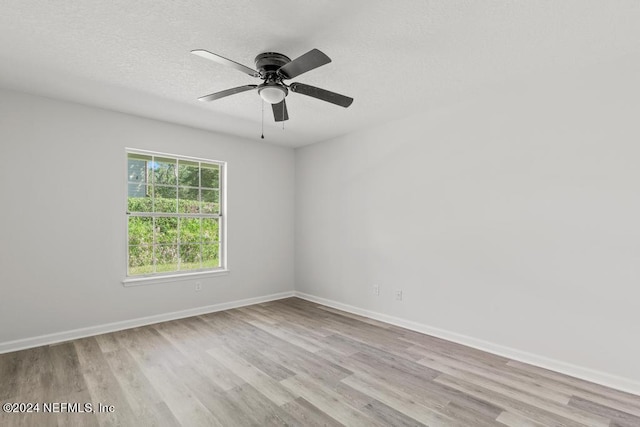 empty room featuring ceiling fan, light hardwood / wood-style floors, and a textured ceiling