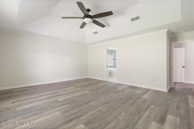 spare room with crown molding, ceiling fan, wood-type flooring, and a tray ceiling