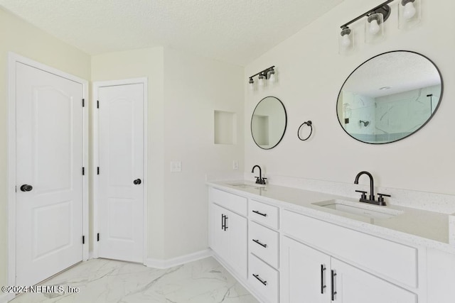 bathroom with vanity, a textured ceiling, and a shower