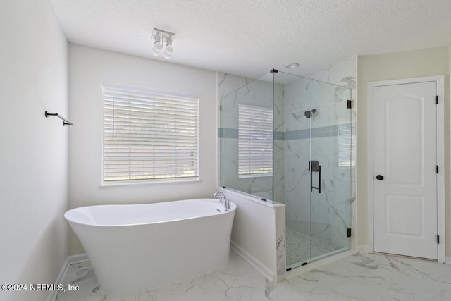 bathroom with shower with separate bathtub and a textured ceiling