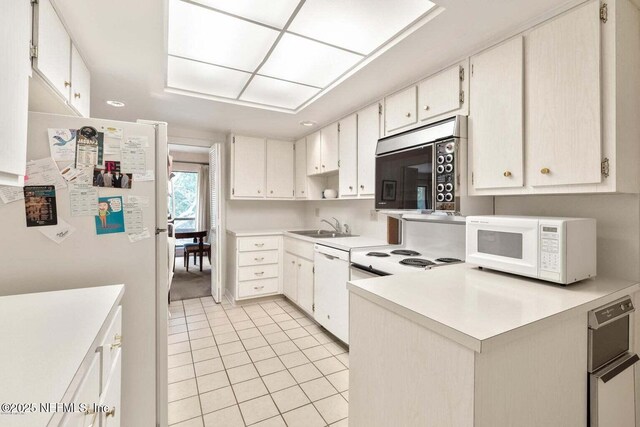 10154 Leisure Ln N Unit 22, Jacksonville, FL 32256 - kitchen with white appliances, light tile patterned floors, sink, and white cabinets