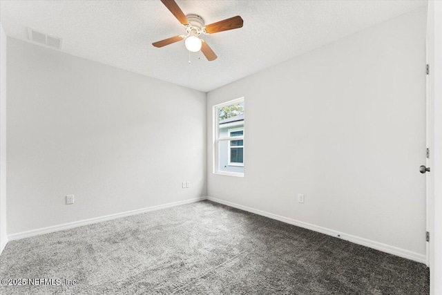 spare room with ceiling fan, a textured ceiling, and dark carpet