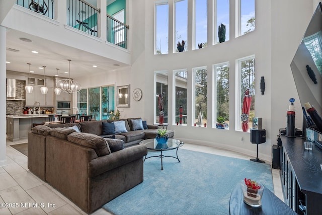 living room featuring an inviting chandelier, light tile patterned flooring, and sink