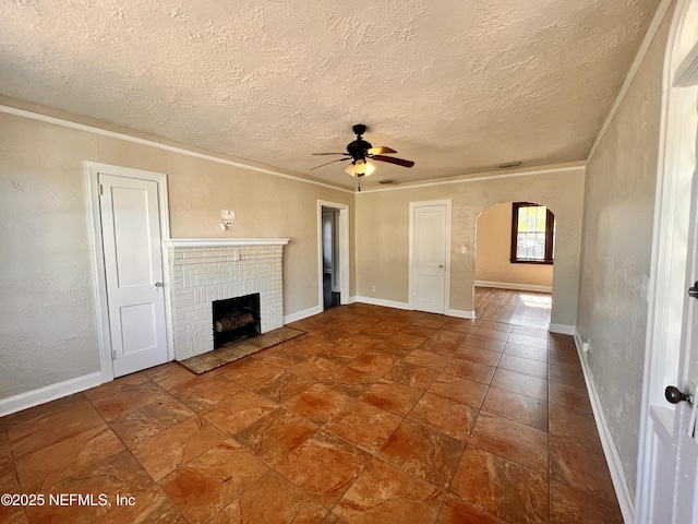 unfurnished living room featuring a textured ceiling, a fireplace, ornamental molding, and ceiling fan