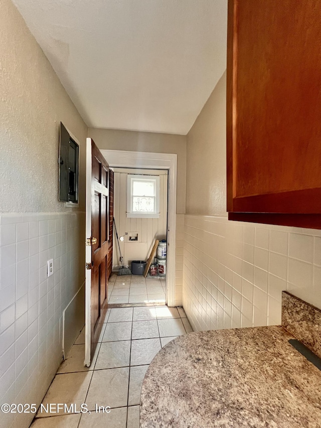 corridor featuring tile walls and light tile patterned flooring