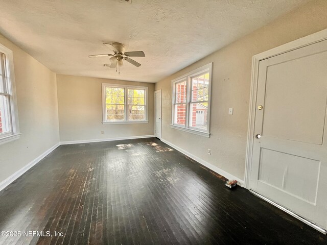 spare room featuring ceiling fan, dark hardwood / wood-style flooring, and a textured ceiling