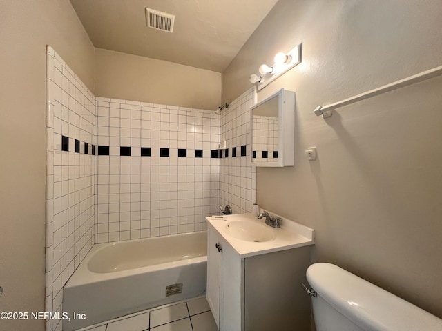 full bathroom featuring tiled shower / bath, tile patterned floors, toilet, and vanity