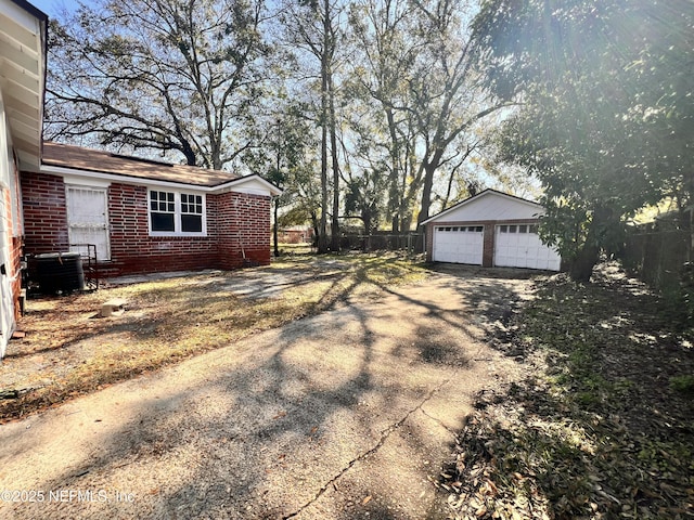 view of side of home featuring a garage, an outdoor structure, and central AC unit