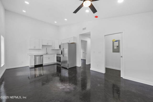 unfurnished living room with sink, high vaulted ceiling, and ceiling fan