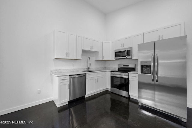 kitchen with stainless steel appliances, white cabinetry, sink, and a towering ceiling