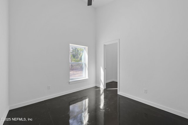 spare room with a high ceiling and ceiling fan