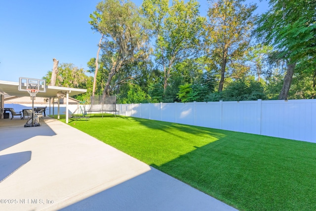 view of yard with a patio and a trampoline