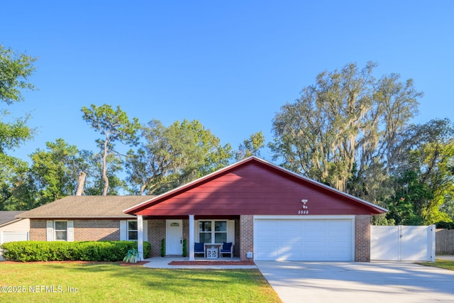 ranch-style house featuring a garage, a front yard, and covered porch