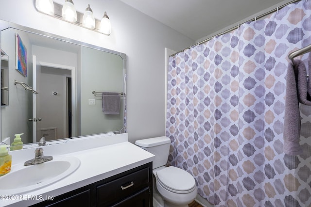 bathroom with vanity, walk in shower, and toilet