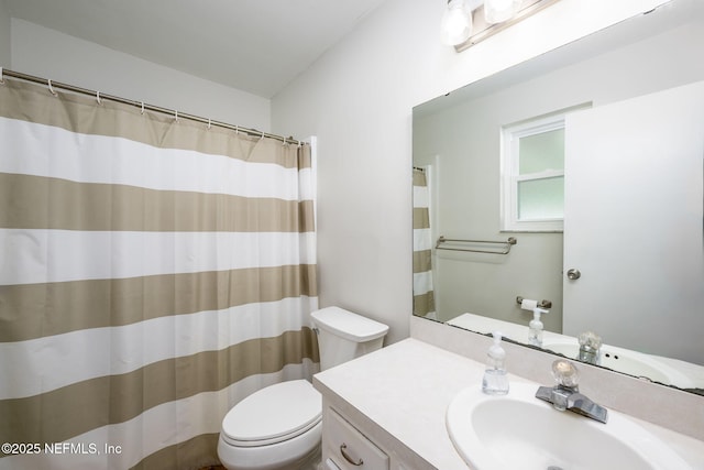 bathroom with vanity, curtained shower, and toilet