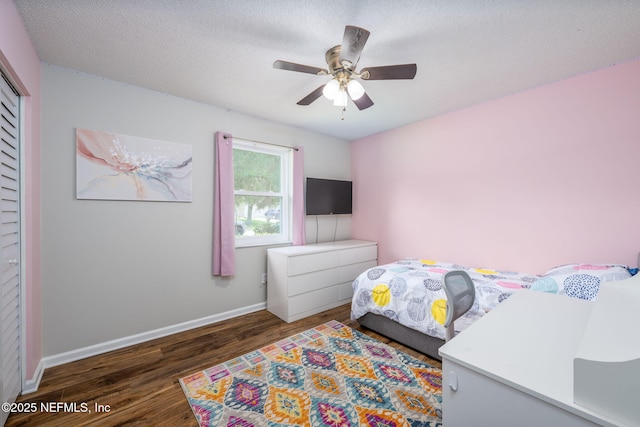 bedroom featuring ceiling fan, dark wood-type flooring, a textured ceiling, and a closet