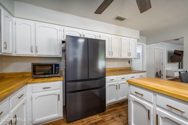 kitchen featuring black refrigerator, wood counters, white cabinets, ceiling fan, and dark wood-type flooring