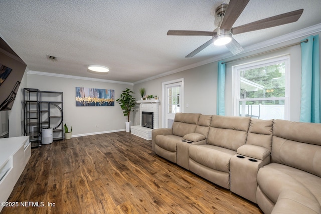 living room with ornamental molding, dark hardwood / wood-style flooring, a brick fireplace, and plenty of natural light