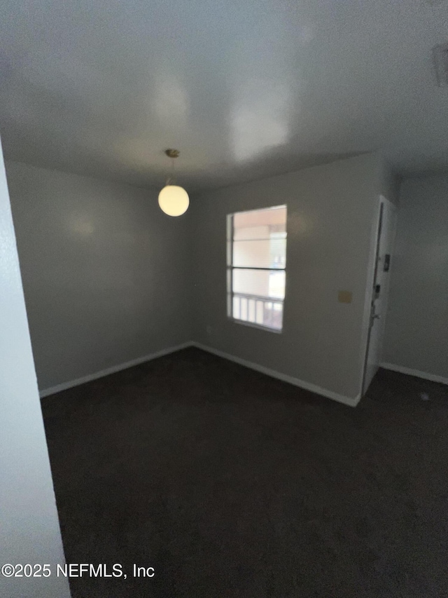 spare room featuring dark carpet