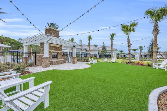 view of yard featuring a pergola and an outdoor stone fireplace